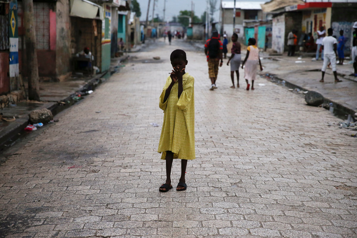 A child stands on a street, after Hurricane Matthew passes Cite-Soleil in Port-au-Prince