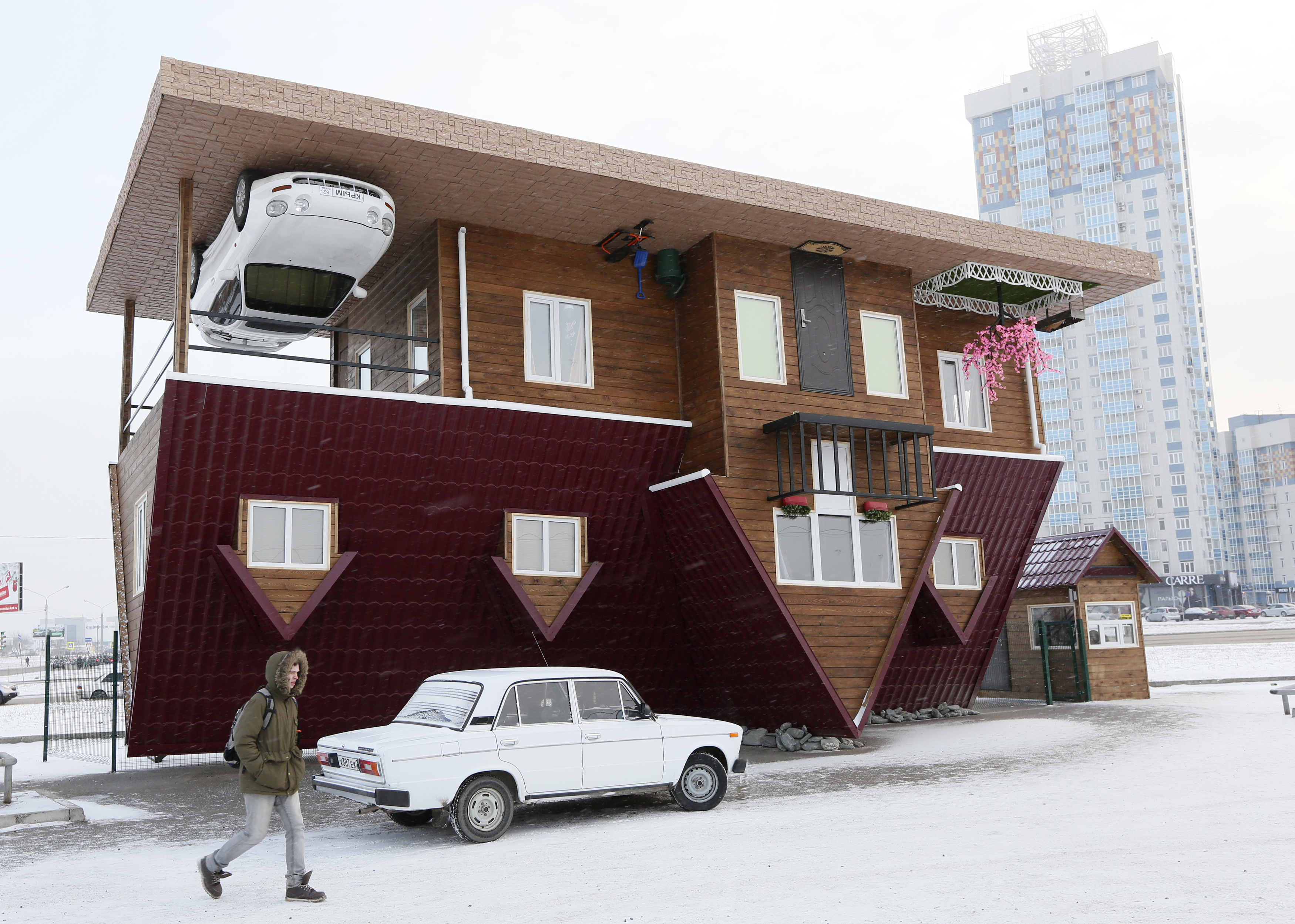 A man passes a house built upside-down in Russia's Siberian city of Krasnoyarsk