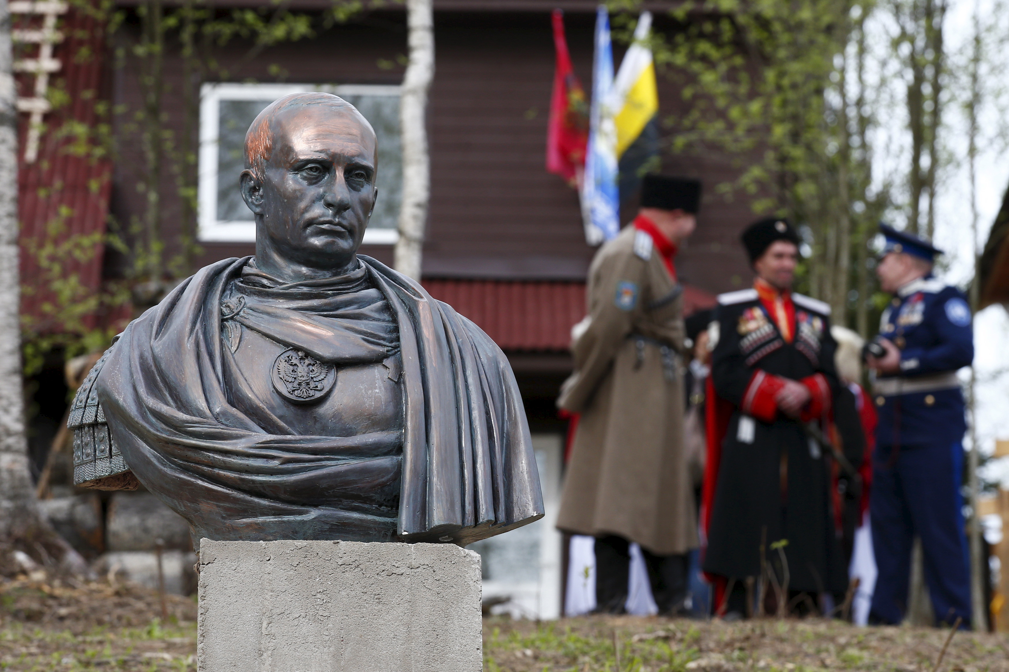 Cossacks stand behind a bust of Russian President Putin which depicts him as a Roman emperor, during its unveiling ceremony in Leningrad region