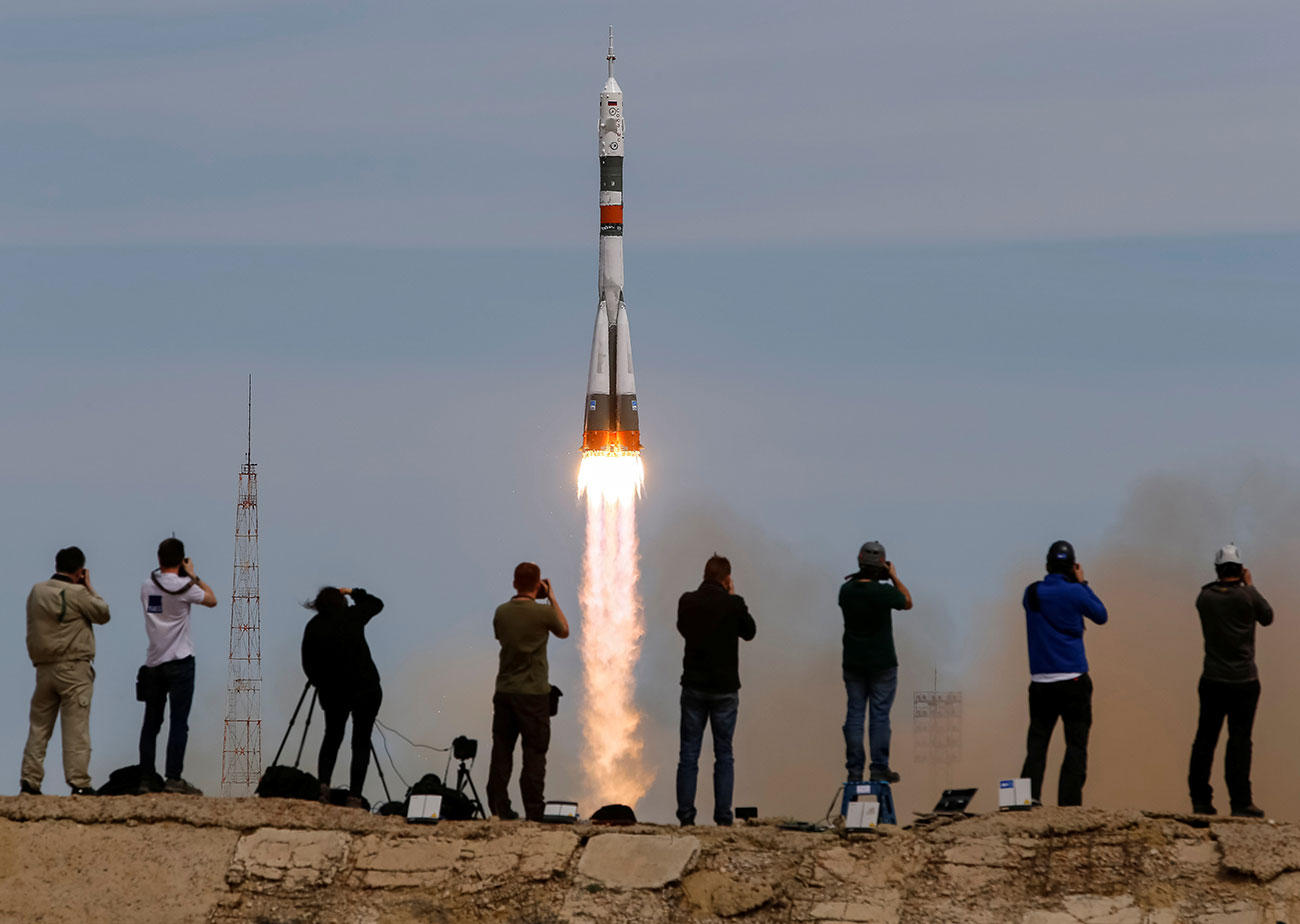 Photographers take pictures as Soyuz MS-04 spacecraft carrying the crew of Fischer of the U.S. and Yurchikhin of Russia blasts off to ISS from the launchpad at the Baikonur Cosmodrome