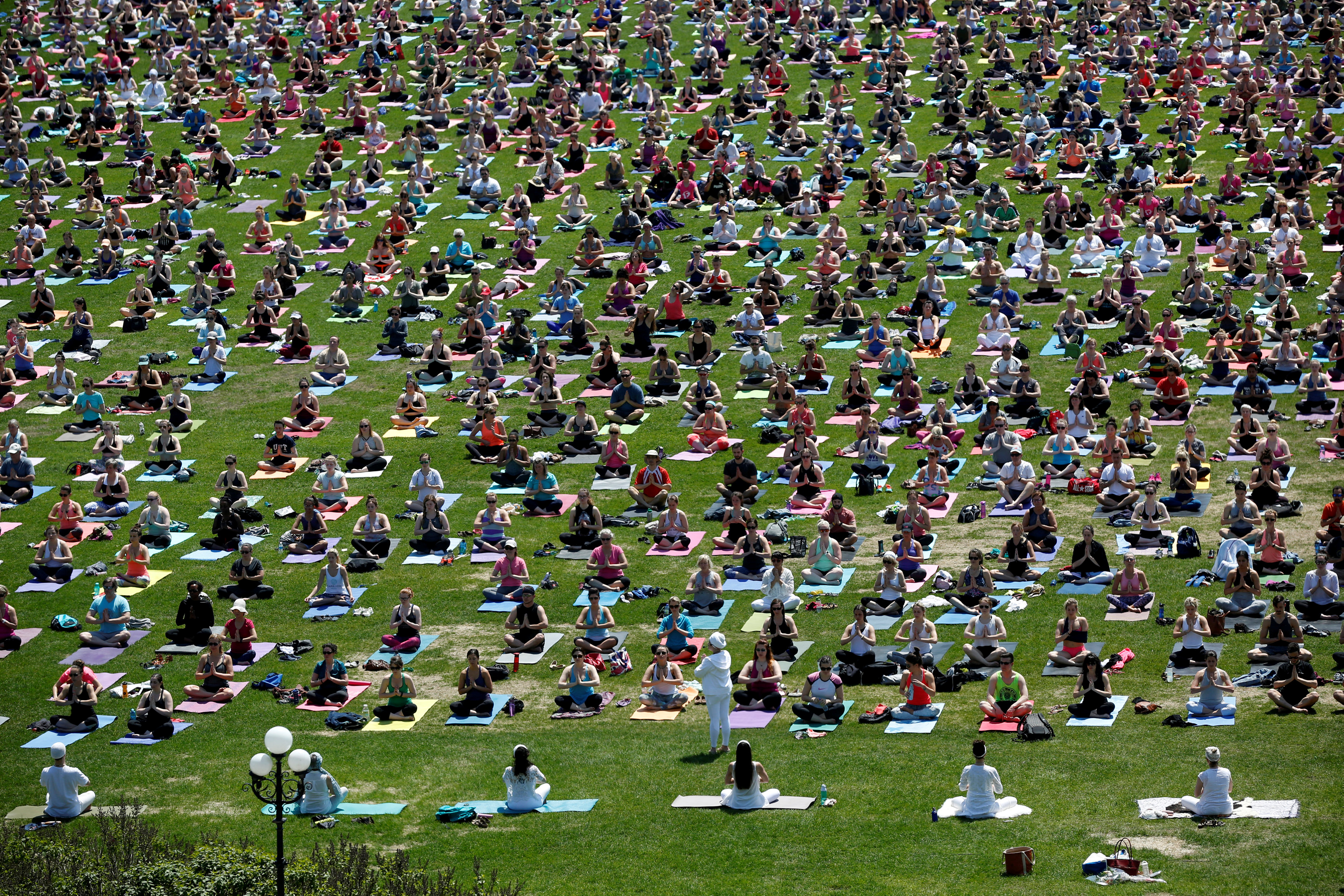 People take part in a weekly yoga class on the front lawn of Parliament Hill in Ottawa