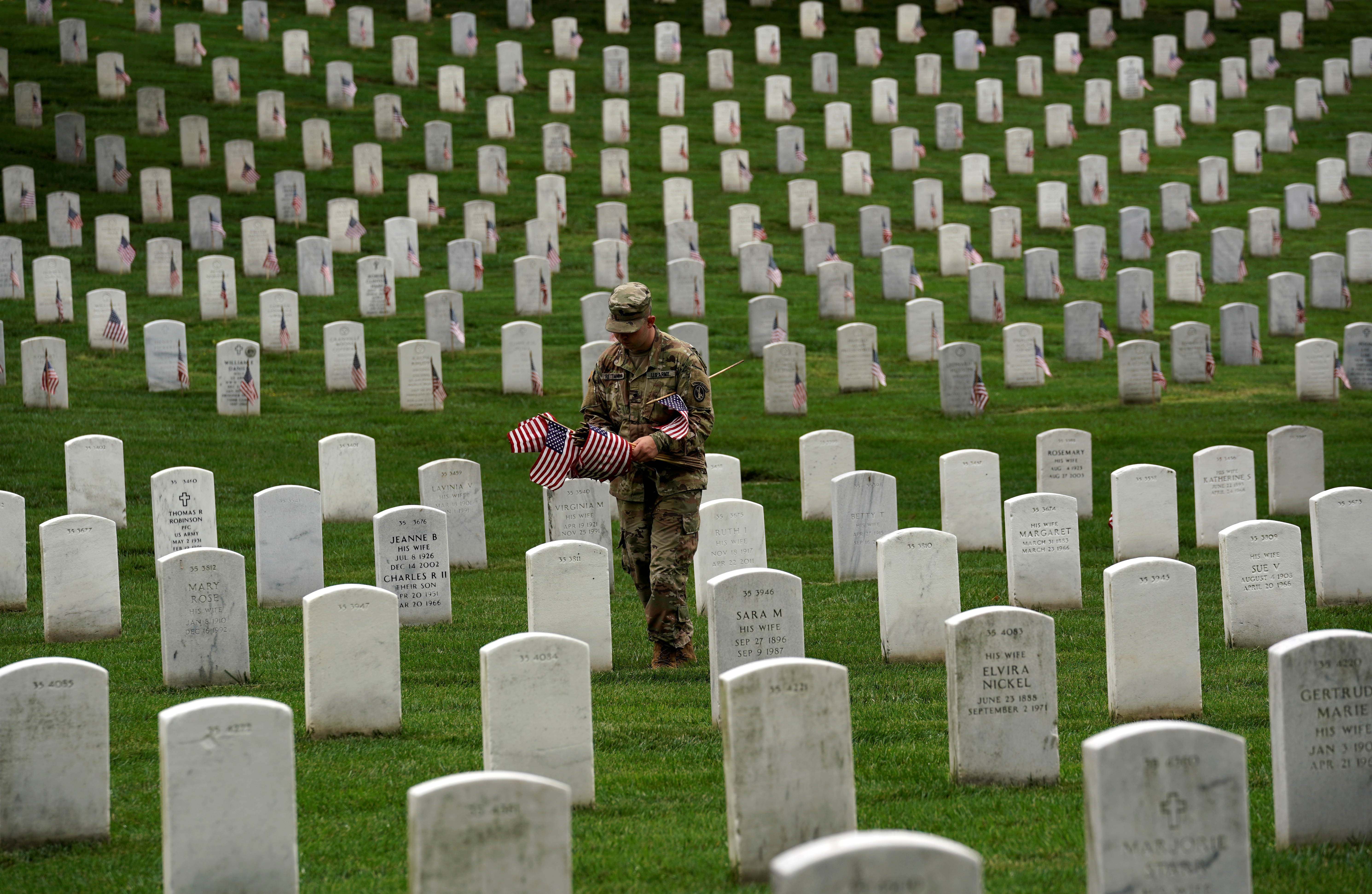 Flags are placed on headstones for Memorial Day at Arlington Cemetery