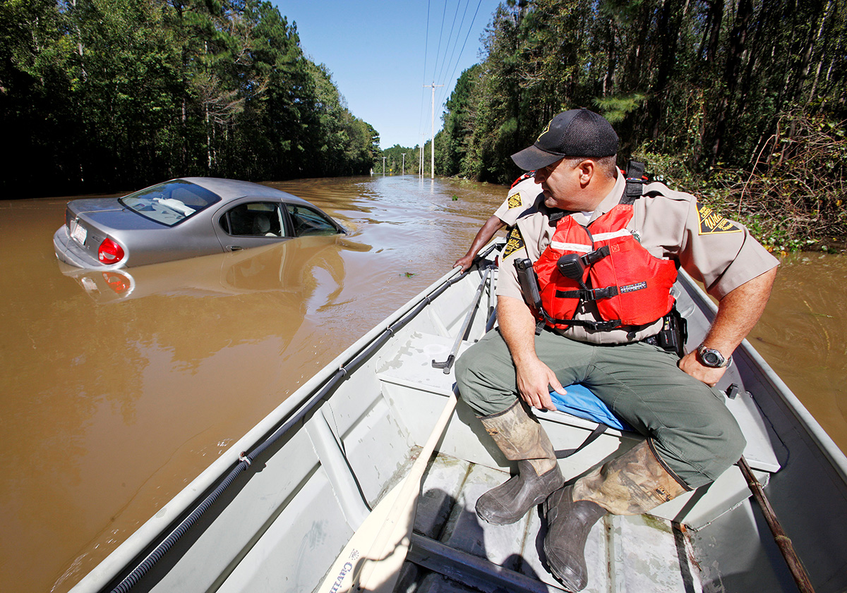 North Carolina Wildlife Resources Commission officers search by boat over a submerged road for those in need of rescue as river waters rise dangerously after Hurricane Matthew hit the state, in Lumberton, North Carolina