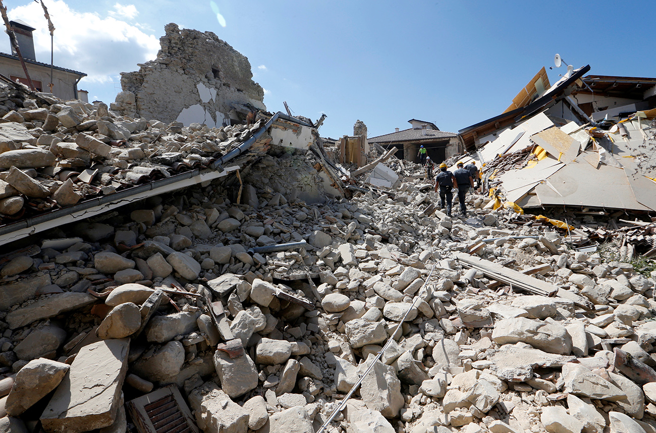 Rescuers work on collapsed buildings following an earthquake in Amatrice