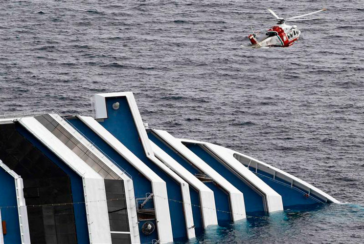 A rescue helicopter flies over the cruise ship.
