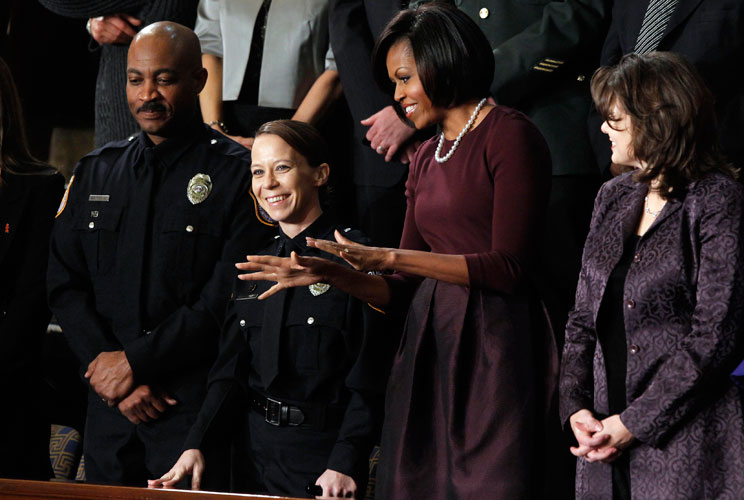 First lady Michelle Obama waves as she stands with Acting Fort Hood Police Chief Mark Alan Todd (left), Federal Police Officer Kimberly Munley (2nd from left) and Rebecca Knerr (right) prior to President Barack Obama's State of the Union Address. Munley f