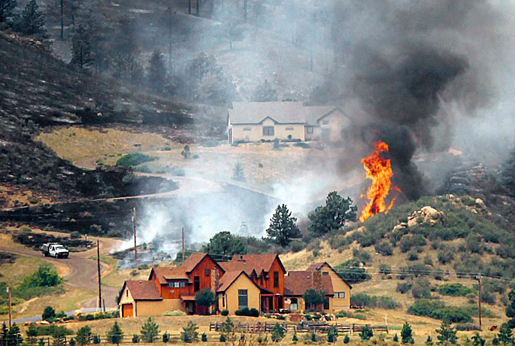 Smoke and flames encroach upon homes on the eastern front of the High Park fire near Laporte, Colorado, June 10, 2012. A wind-driven wildfire burning in the rugged Colorado canyon spread out of control, forcing hundreds of people to evacuate; one person i
