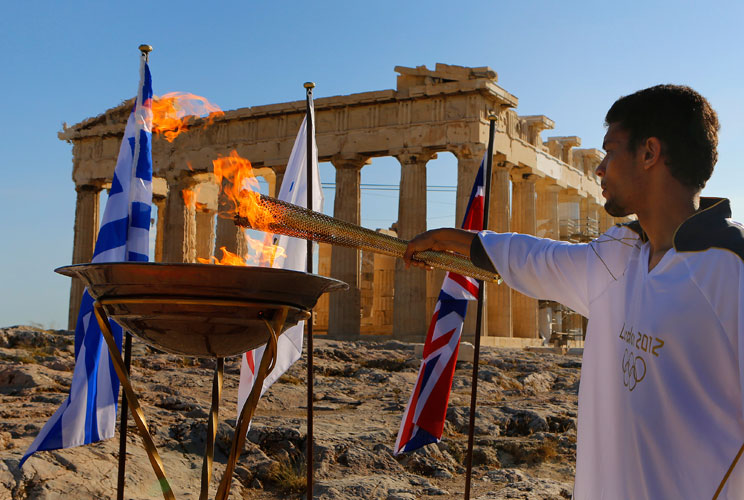 Torchbearer Dimitrios Chondrokoukis, a Greek high jump athlete, lights a cauldron with the Olympic Flame atop the Athens Acropolis May 16, 2012. The Olympic flame will be handed over to the London 2012 delegation on Thursday. REUTERS/Yannis Behrakis (GREE