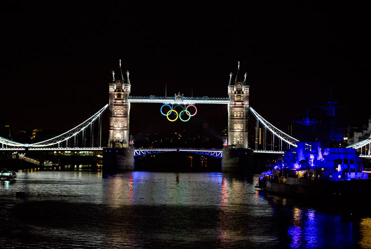 A view of the Tower Bridge is seen as it is lit up to celebrate the Olympics in London July 21, 2012. REUTERS/Neil Hall (BRITAIN - Tags: SPORT OLYMPICS CITYSPACE)