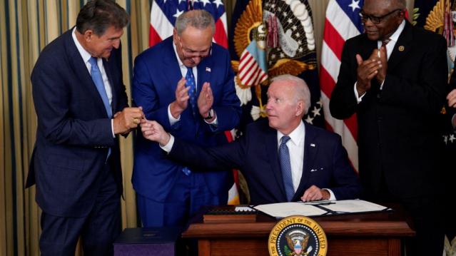 Biden signed the bill and gave the pen to Manchin.
