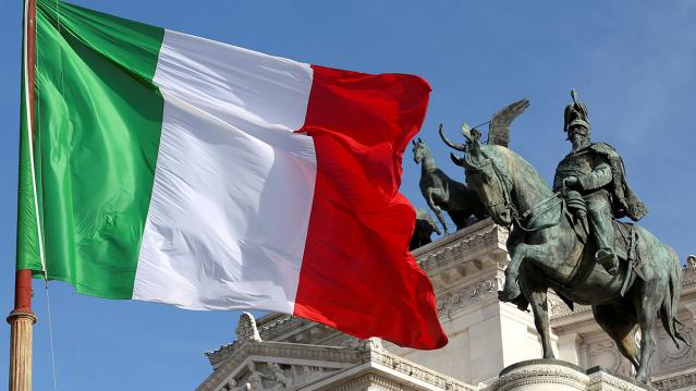 The Italian flag waves in front of The &quot;Altare della Patria&quot; also known as &quot;Vittoriano&quot; downtown Rome