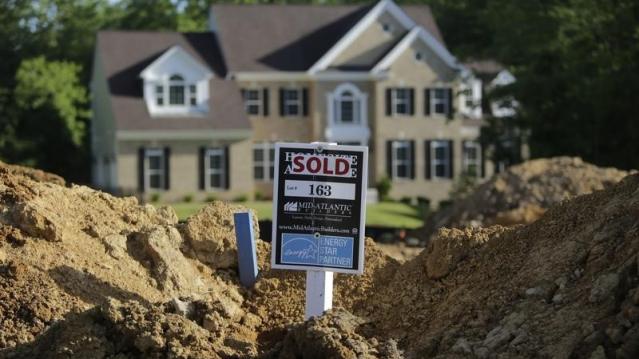 A completed house (rear) is seen behind the earthworks of a home currently under construction at the Mid-Atlantic Builder&#039;s &#039;The Villages of Savannah&#039; development site in Brandywine, Maryland May 31, 2013.   REUTERS/Gary Cameron  