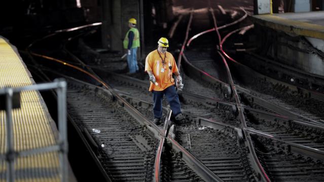 FILE PHOTO: Workers walk on rail tracks inside New York City&#039;s Pennsylvania (Penn) Station, U.S. April 27, 2017. REUTERS/Mike Segar/File Photo