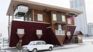 A man passes a house built upside-down in Russia&#039;s Siberian city of Krasnoyarsk