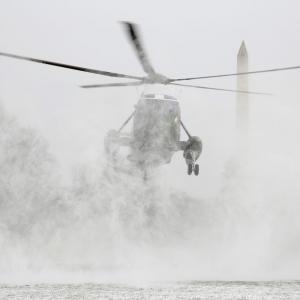 Marine One blows up a cloud of snow as it lands on the South Lawn of the White House in Washington.