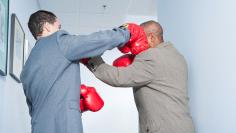 Businessmen fighting in office