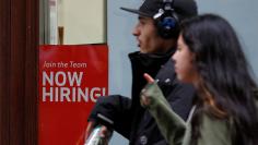 People walk past a "Now Hiring" sign in Manhattan in New York