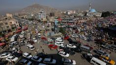 Vehicles drive at a junction in downtown Kabul