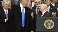 President Donald Trump and House Ways and Means Committee Chairman Kevin Brady smile at each other after the U.S. Congress passed sweeping tax overhaul legislation, on the South Lawn of the White House in Washington
