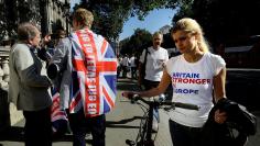 A vote remain supporter walks past a vote leave supporter outside Downing Street in London