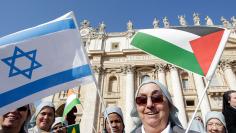 A nun holds Israeli and Palestinian flags before Pope Francis arrives to lead the general audience in St. Peter's Square at the Vatican