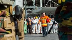 Staff members at Brussels national airport and rescuers stand outside the terminal for a ceremony following bomb attacks in Brussels metro and Belgium's National airport of Zaventem