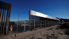 A worker stands next to a newly built section of the U.S.-Mexico border fence at Sunland Park, U.S. opposite the Mexican border city of Ciudad Juarez