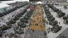 Visitors walk near exhibits, which are on display at the Army-2015 international military-technical forum in Kubinka