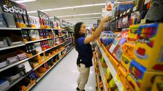 Walmart department manager Karren Gomes helps stock shelves with school supplies as the retail store prepare for back to school shoppers in San Diego, California
