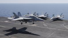 A F/A-18E/F Super Hornets of Strike Fighter Attack Squadron 211 (VFA-211) lands on the flight deck of the USS Theodore Roosevelt (CVN-71) aircraft carrier in the Gulf