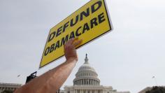 A man holds a sign at the Tea Party Patriots 'Exempt America from Obamacare' rally on the west lawn of the U.S. Capitol in Washington