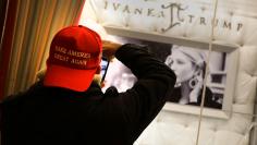 A man wearing a "Make America Great Again" cap takes a picture of Ivanka Trump jewelry display window inside Trump Tower in New York City