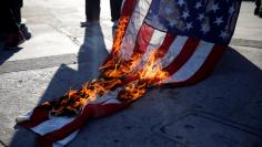 Activists burn a flag while protest on the corner of Florence Ave and Normandie Ave against the police shootings that lead to two deaths in Louisiana and Minnesota, respectively, in Los Angeles, California
