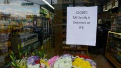 A sign saying "My family is detained at JFK" hangs in the window of a closed bodega during a Yemeni protest against President Donald Trump's travel ban, in the Brooklyn borough of New York City