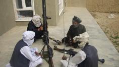 Taliban fighters pose with weapons as they sit in their compound at an undisclosed location in southern Afghanistan in this May 5, 2011 file picture.  REUTERS/Stringer  