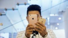 A man takes pictures as Apple iPhone 6s and 6s Plus go on sale at an Apple Store in Beijing, China September 25, 2015. REUTERS/Damir Sagolj/File Photo 