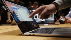 A guest points to a MacBook Pro during an Apple media event in Cupertino, California, U.S. October 27, 2016.   REUTERS/Beck Diefenbach 