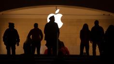 A police officer is silhouetted against the Apple logo in Grand Central Terminal in New York
