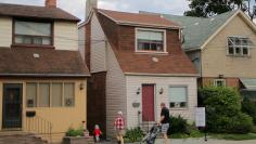 FILE PHOTO: A family passes a house for sale on Mount Pleasant Road in Toronto