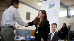 Jessica Kolber shakes hands with a job seeker at a job fair in Burbank, Los Angeles