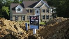 A completed house (rear) is seen behind the earthworks of a home currently under construction at the Mid-Atlantic Builder's 'The Villages of Savannah' development site in Brandywine, Maryland May 31, 2013.   REUTERS/Gary Cameron  