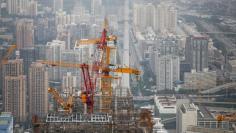 Cranes are seen on top of a skyscraper that is under construction in Beijing, China August 26, 2017. REUTERS/Thomas Peter 