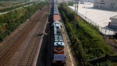 A train carrying containers from London arrives at the freight railway station in Yiwu