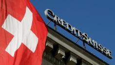 FILE PHOTO: Switzerland's national flag flies next to the logo of Swiss bank Credit Suisse at a branch office in Luzern, Switzerland October 19, 2017.   REUTERS/Arnd Wiegmann /File Photo