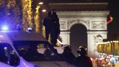 Masked police stand on top of their vehicle on the Champs Elysees Avenue after two policemen were killed and another wounded in a shooting incident in Paris, France, April 20, 2017. REUTERS/Christian Hartmann