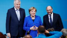 Acting German Chancellor Angela Merkel, leader of the Christian Social Union in Bavaria (CSU) Horst Seehofer and Social Democratic Party (SPD) leader Martin Schulz pose for a photo at a news conference after exploratory talks about forming a new coalitio