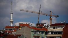 FILE PHOTO: A construction crane is seen behind residential buildings in Istanbul, Turkey May 24, 2017. REUTERS/Murad Sezer