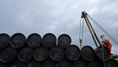 A worker prepares to transport oil pipelines to be laid for the Pengerang Gas Pipeline Project at an area 40km (24 miles) away from the Pengerang Integrated Petroleum Complex in Pengerang, Johor, February 4, 2015.  REUTERS/Edgar Su/Files  