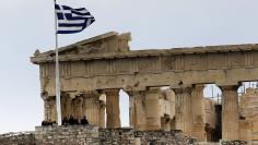 Tourists stand near the temple of Parthenon atop the ancient site of the Athens Acropolis on a cold and windy day January 30, 2015. Greece will refuse the planned return of European Union and International Monetary Fund inspectors to the country since the