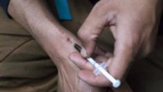 FILE PHOTO - A man injects himself with heroin using a needle obtained from the People's Harm Reduction Alliance, the nation's largest needle-exchange program, in Seattle